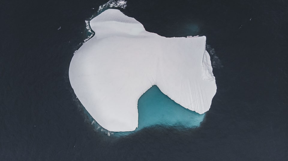 A vertical shot of an iceberg taken 1km from the shore and at an altitude of 100m