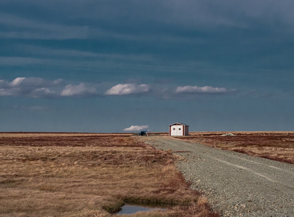 In the middle of nowhere, a small stretch of road and a barn are the only reminder of civilization
